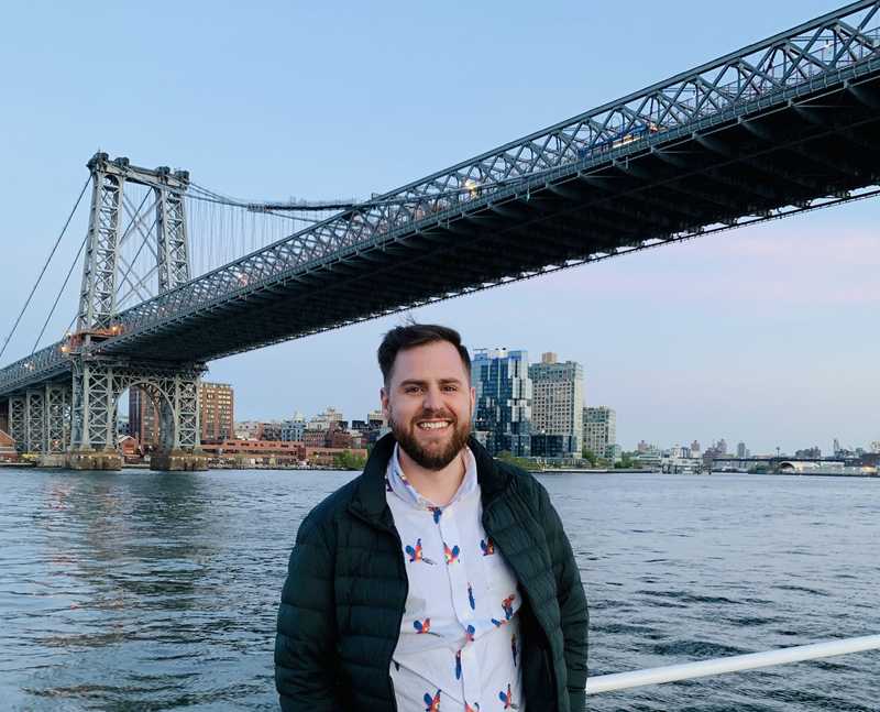 A picture of Trevor Harmon in front of the manhattan bridge
