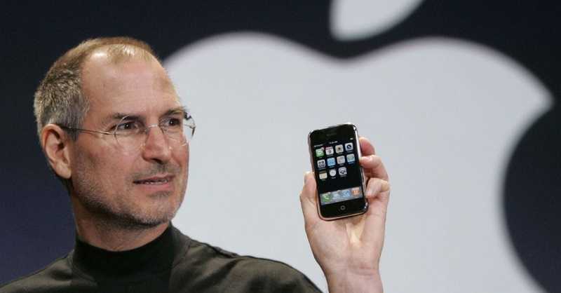 Steve Jobs holding the original iPhone